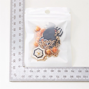 Détail de parure bijoux chat citrouille Halloween avec emballage et échelle de mesure
