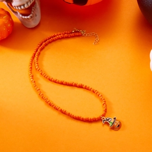 Close-up of Halloween beaded necklace featuring pumpkin pendant and gold lobster clasp