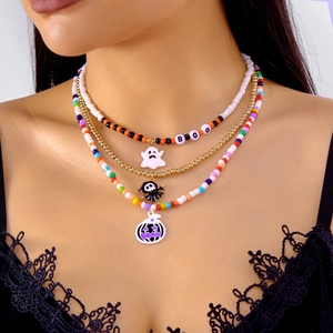Detail of layered Halloween beaded necklace with BOO charms and ghost pumpkin pendants