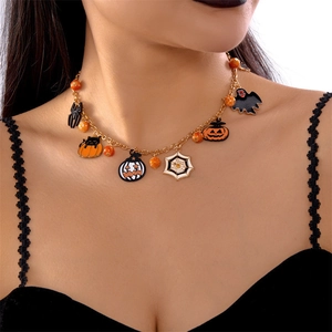 Gros plan d'un collier d'Halloween avec pendentifs chat, citrouille et fantôme dorés
