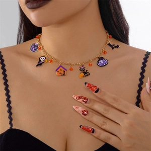 Détail du collier d'Halloween avec pendentifs chat noir et citrouille sur chaîne dorée