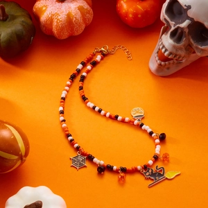 Handmade Halloween beaded necklace featuring pumpkin cat and spider web enamel charms