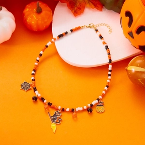 Macro detail of handmade Halloween beaded necklace with pumpkin and ghost charms