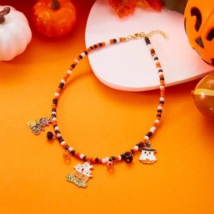 Macro shot of Halloween beaded necklace with ghost charms and wicked pumpkin pendant