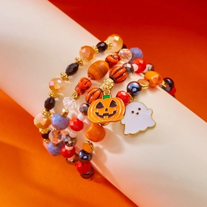 Λεπτομέρεια από βραχιόλια με χάντρες Halloween με κρεμαστά κολοκύθα και φάντασμα σε πορτοκαλί φόντο