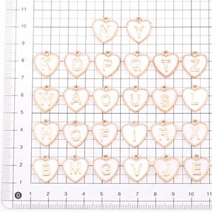 Gouden hartvormige letterhangers met emaille op een rasterachtergrond voor meting