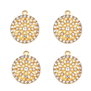 Gros plan de quatre pendentifs flocon de neige en alliage doré avec strass blancs brillants