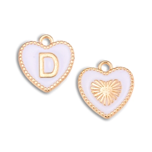 Detail van een hartvormige hanger met gouden letter D en wit emaille voor sieraden