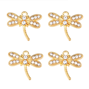 Détail de quatre breloques libellules dorées avec strass pour création de bijoux DIY