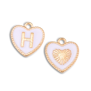 Detail van hartvormige hangers met witte oliedruppel en gouden letter H voor sieraden