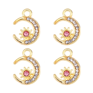 Détail de pendentifs soleil et lune dorés avec strass roses et blancs sertis
