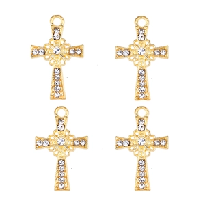Détail de quatre breloques croix dorées évidées avec incrustations de strass brillants