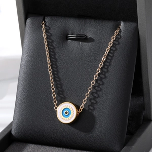 Golden Turkish Evil Eye pendant necklace with blue enamel on a black jewelry box