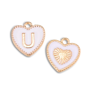 Detailopname van hartvormige gouden hangers met wit emaille en de letter U