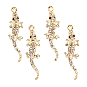 Détail de quatre pendentifs crocodile dorés avec strass pour la création de bijoux DIY