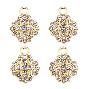Détail de quatre pendentifs trèfles dorés sertis de cristaux pour bijoux artisanaux