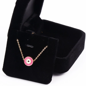 Golden Turkish Evil Eye necklace with pink enamel pendant in a black velvet jewelry box