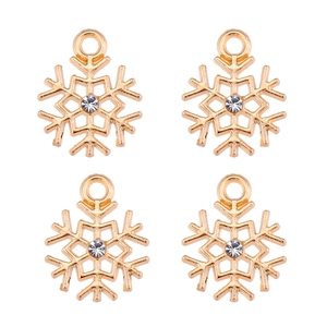 Vue macro de quatre pendentifs flocon de neige en alliage doré avec strass central