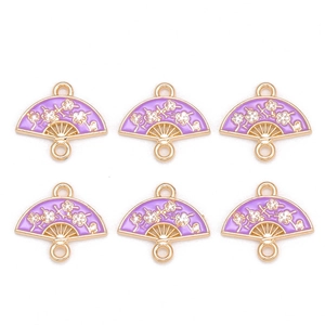 Détail de breloques éventail en émail lilas avec fleurs de prunier et bords dorés