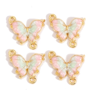 Détail de breloques papillon en émail dégradé avec bords dorés et doubles anneaux pour DIY