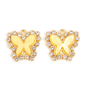Macro view of butterfly pendant with gold plating, sparkling rhinestones and pearl finish