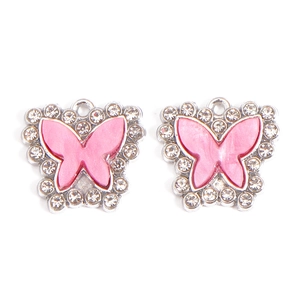 Detail view of pink butterfly charms with marble texture and sparkling rhinestones