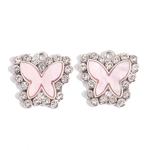 Macro detail of silver butterfly pendants with pink pearlescent inlay and rhinestones