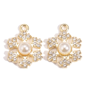 Detailed view of alloy snowflake charms with embedded pearls and sparkling rhinestones