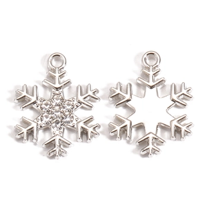 Detailed view of silver snowflake charms with rhinestones and hollow metal patterns