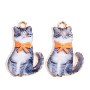 Dettaglio di ciondoli a forma di gatto tigrato con fiocchi arancioni per gioielli fai da te