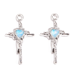 Detailed macro view of melting silver cross pendants with blue heart zircon inlays