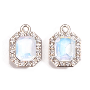 Macro view of rectangular emerald-cut charms with AB rainbow stones and zircon borders