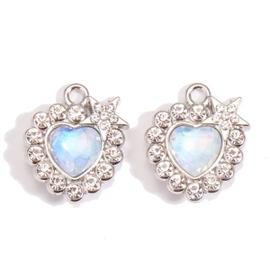 Macro detail of Y2K heart moon pendants with iridescent crystals and alloy metal