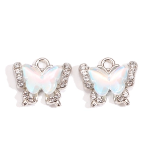 Detailed view of iridescent butterfly pendants with rhinestone edges for DIY jewelry making