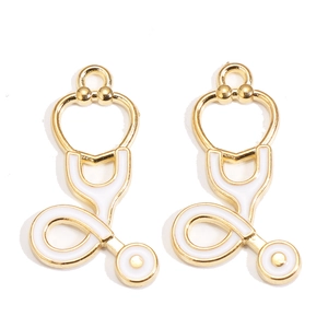 Détail de deux pendentifs stéthoscope dorés avec émail blanc pour la création de bijoux