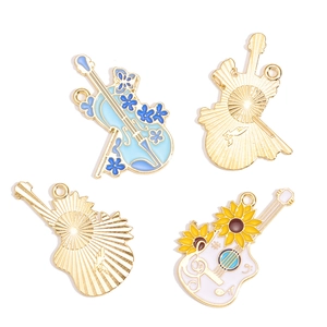 Enamel musical instrument pendants featuring blue violin and white guitar with floral motifs
