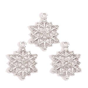 Detailed close-up of three silver snowflake charms with inlaid rhinestones for DIY jewelry