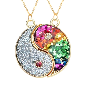 Macro-opname van gouden Tai Chi hanger met kleurrijke regenboog glitters en zilveren pailletten
