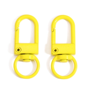 Detail of two bright yellow swivel lobster clasps with polished metal finish