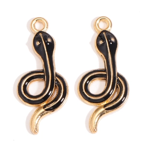 Detail of snake charms with golden alloy base and black enamel finish for DIY jewelry