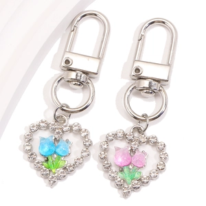 Porte-clés cœur en strass avec tulipes en rose et bleu sur un fond blanc épuré et lisse