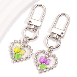 Pendentifs cœur tulipe scintillants avec bordure strass et fermoir argent sur fond blanc