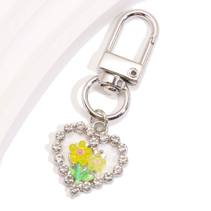 Détail d'un porte-clés en forme de cœur avec tulipe jaune et strass brillants