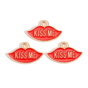 Detailed view of three red enamel kiss me lip charms with gold plating and hanging loops