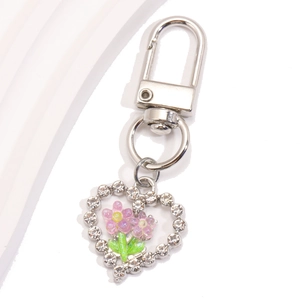 Vue détaillée du porte-clés en forme de cœur avec fleurs roses et strass brillants
