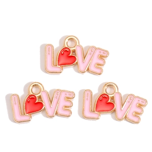 Detail of LOVE charm pendants with red hearts and pink enamel for DIY jewelry