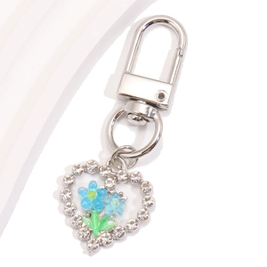 Vue macro du porte-clés cœur en cristal avec tulipes bleues émaillées et argent