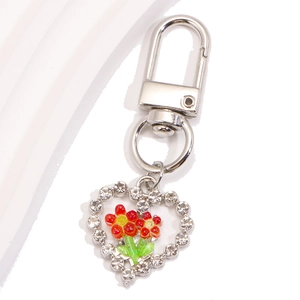 Détail macro du porte-clés en forme de cœur avec strass, tulipe en métal et mousqueton