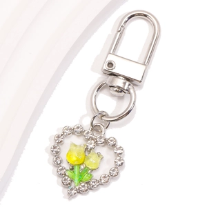 Détail du porte-clés cœur argenté avec strass brillants et breloques tulipes jaunes