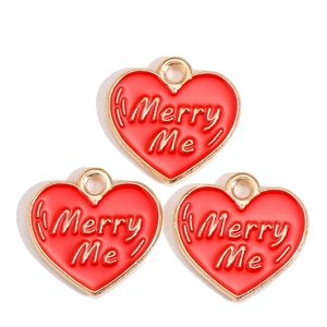 Macro detail of red enamel heart charms with gold edges and Merry Me engraving